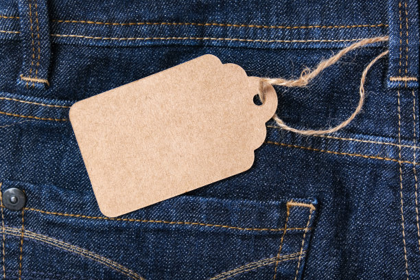 工艺空白标签上的深蓝色牛仔裤的背景，销售和折扣的概念图片下载