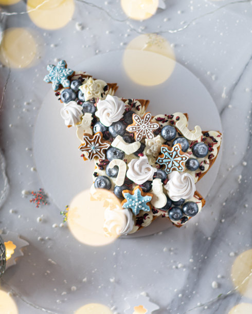圣诞水果蛋糕装饰蛋白酥，姜饼曲奇，雪花，蓝莓。垂直图片下载