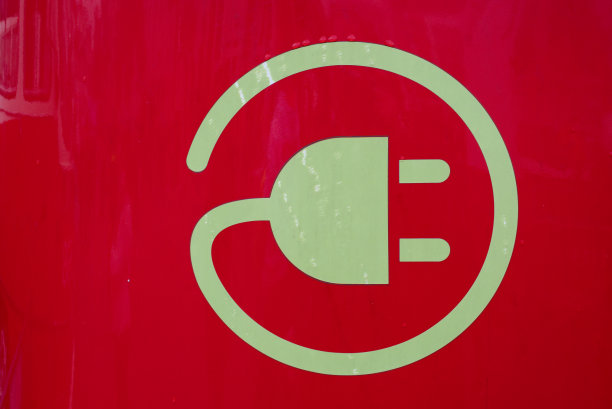 红色电动公共交通工具上的充电符号。图片下载