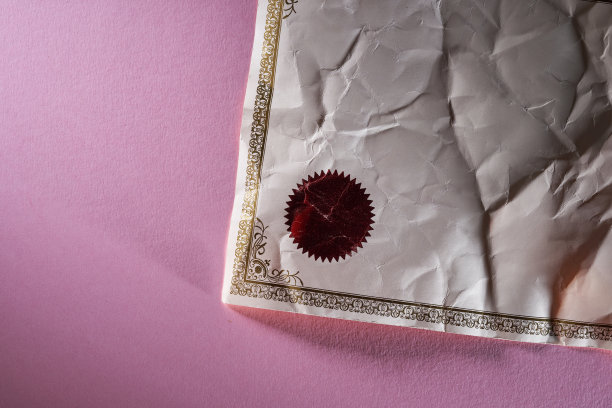 粉红色背景上皱巴巴的证书图片下载