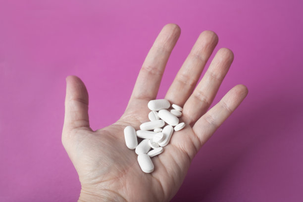 女人的手掌，白色背景上有许多药丸图片下载