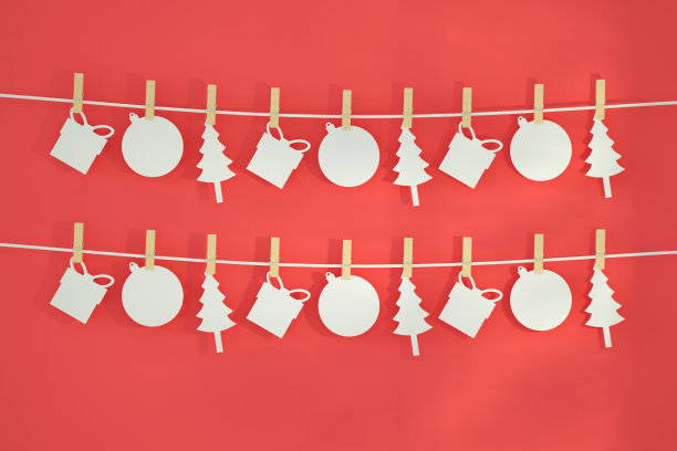 新的一年，在红色背景上有衣夹的圣诞装饰品图片下载