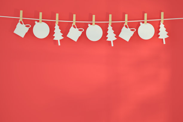 新的一年，在红色背景上有衣夹的圣诞装饰品图片下载
