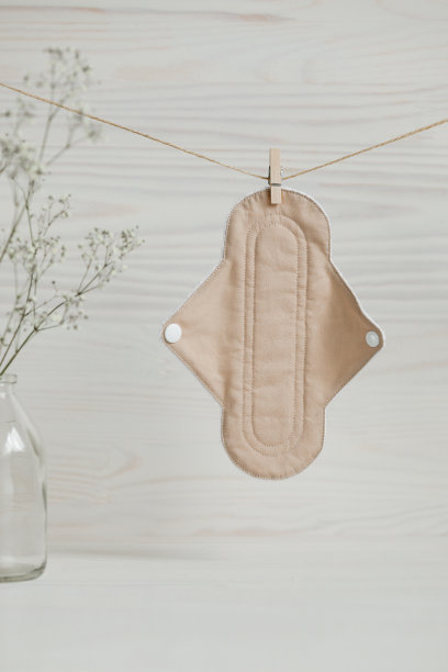 环保可重复使用的有机生物棉垫，悬挂在木制背景的绳上，并配有满天星。零废物可重复使用可洗布垫。图片下载