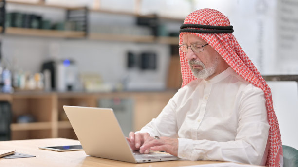 在笔记本电脑上工作的阿拉伯商人图片下载