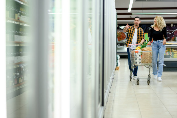 一对夫妇在超市买菜时推着购物车图片下载