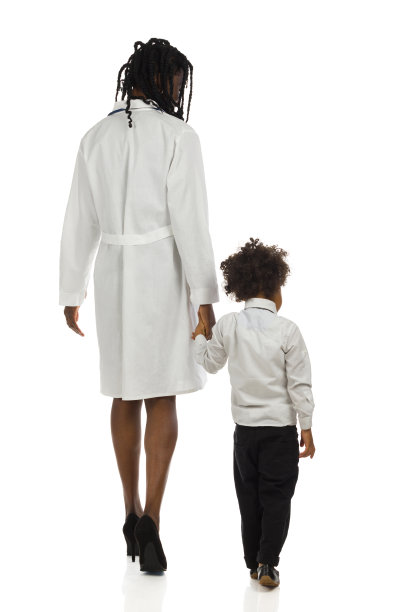 黑人女医生和小男孩走着。后面的观点。完整的孤立。图片下载
