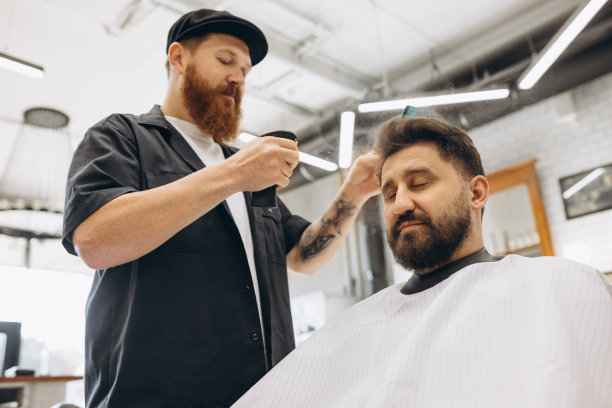 一个男人在理发店理发。专业理发师在工作过程中。美容、自我护理、时尚、时尚、保健和男性化妆品概念。图片下载