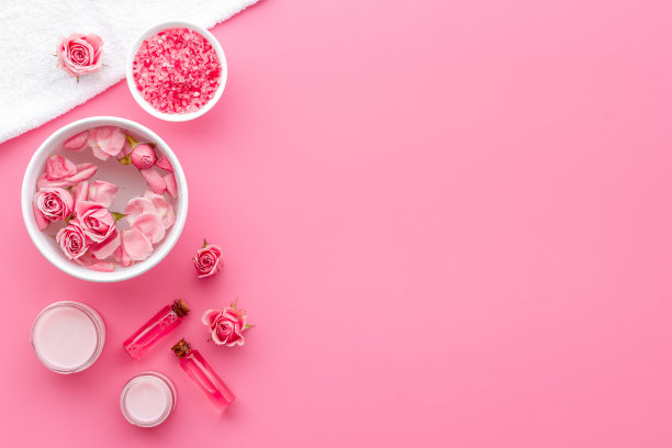 粉红玫瑰水与精油和化妆品水疗。俯视图图片下载