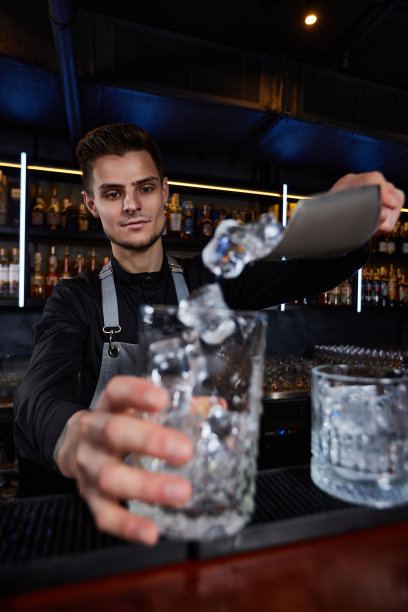 酒保把冰块放进玻璃杯里图片下载