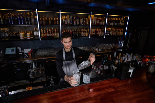 酒保把冰块放进玻璃杯里图片下载