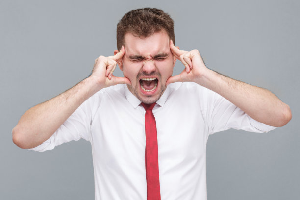 一个男人站在那里，摸着他痛苦的头尖叫图片下载