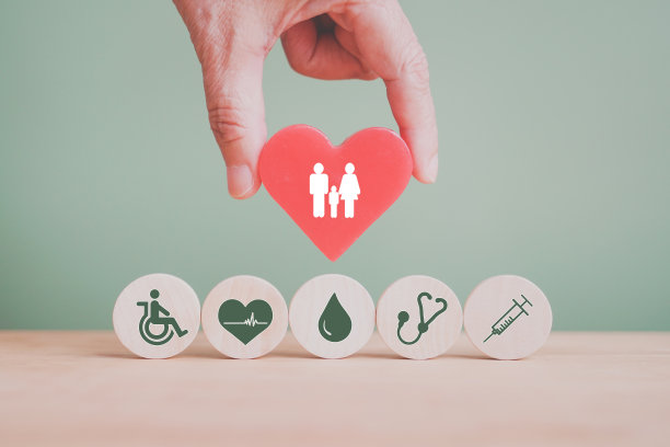 手握红心与家庭图标与健康和医疗图标在圆木为家庭健康保险概念图片下载