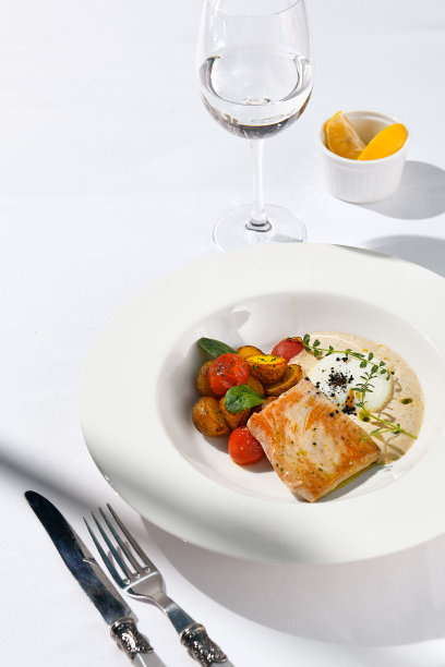 鱼排配金枪鱼片，热番茄，烤土豆和金枪鱼酱汁。白盘子里的鱼。金枪鱼酱和蔬菜。当代海鲜餐厅菜单，夏日阳光与阴影。图片下载