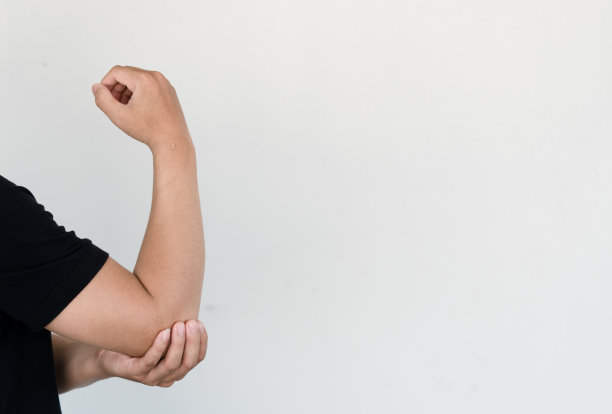 男人用他们的手来抓住他们的肘部，他的肘部很痛。痛苦的健康和医学概念。图片下载