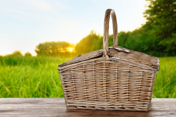公园里木桌上的柳条野餐篮图片下载