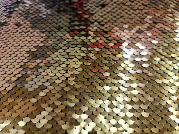 近距离观察金色亮片织物样品图片下载
