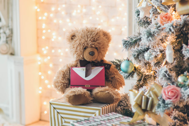 泰迪熊手里拿着给圣诞老人的信。圣诞树附近。圣诞节，新年背景。图片下载