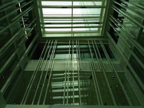 办公大楼内部透明屋顶下的景观包括玻璃窗、钢材和铝合金——室内设计与建筑工程图片下载