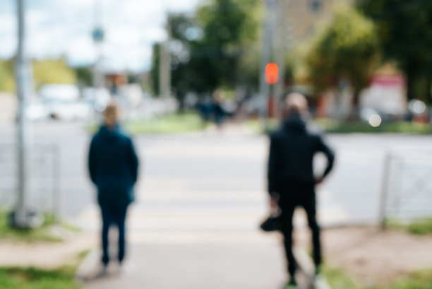 后视镜人们站在人行横道前面的一个红色的交通灯，在户外，散焦图片下载