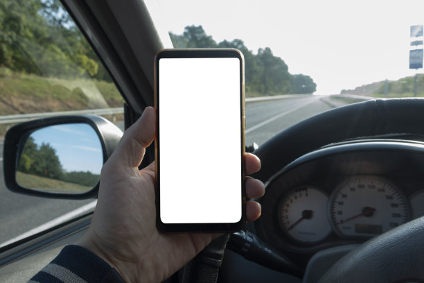 带有隔离屏幕的现代智能手机模型。司机在路上使用电话。图片下载