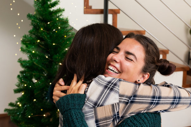 年轻的白种人姐妹在圣诞节互相拥抱。幸福。感情。爱图片下载