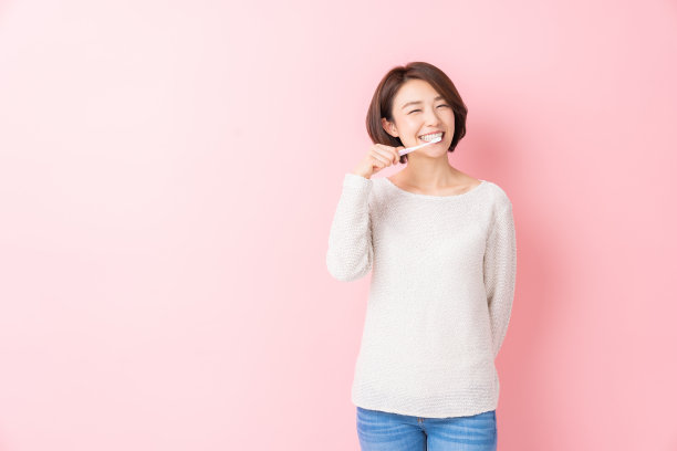 漂亮的亚洲女人用健康的牙齿拿着牙刷，口腔护理图片下载