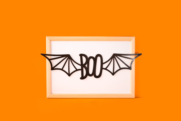 万圣节概念快乐。万圣节手工纸装饰，蝙蝠翅膀的boo文本框在橙色背景。万圣节节日派对，贺卡模型空白与复制空间图片下载