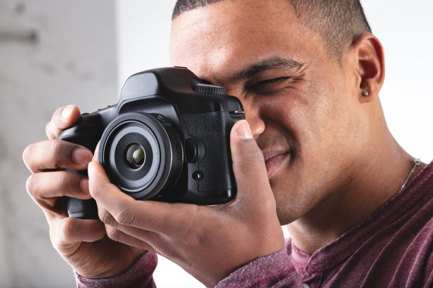 年轻的男摄影师在相机上构图图片下载