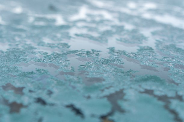 有选择性的重点。一辆冰冻汽车上的初霜，晚秋特写。美丽的抽象冰冻微观图案。霜冻天气在自然界起作用。冬天的背景图片下载