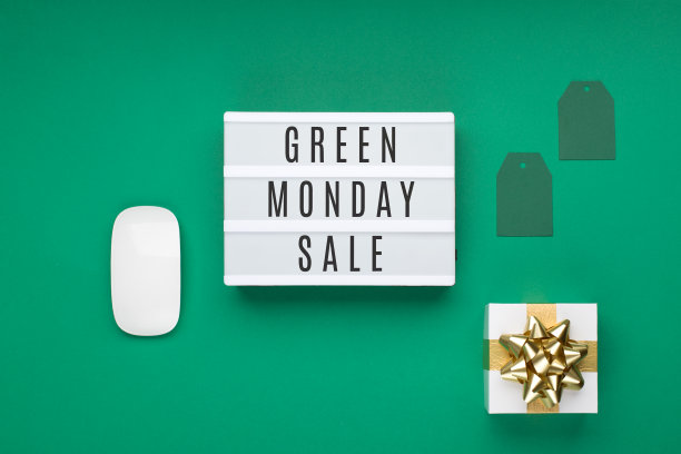 绿色星期一销售文本白色灯箱与金色礼品盒和绿色背景上的纸标签。图片下载