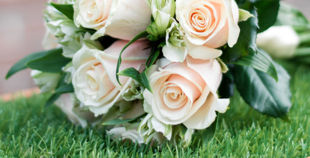 婚礼花束躺在绿色的草地上，白色和绿色的花朵在一束，鲜花的特写图片下载