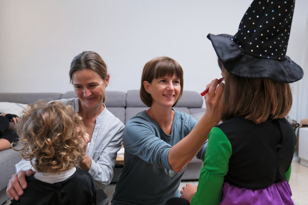 姐妹们为她们的女儿画万圣节派对。图片下载