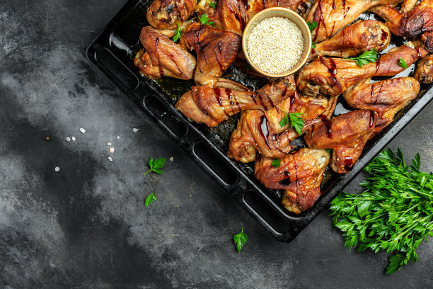 烤鸡腿，烤鸡翅，在烤盘上煎炸，自制美食美味丰盛。食品配方的背景。近距离图片下载