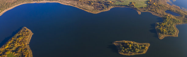 秋天的森林和湖泊。从上面看。在晴朗的秋日空中拍摄的一个湖上的岛屿。图片下载