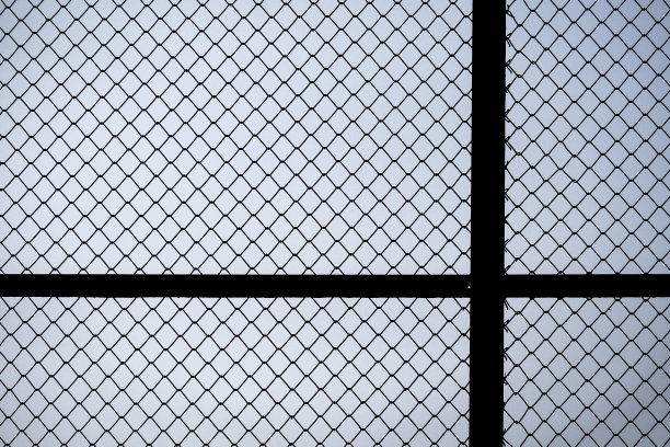 房子旁边的铁网映着傍晚的天空。图片下载