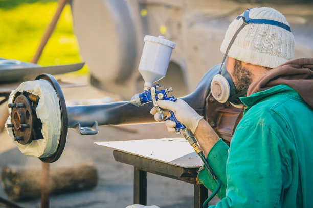 在修复一辆老爷车的过程中，一个拿着自动空气喷枪的人在行动。在旧的大差速器或后桥上涂第一层油漆。图片下载