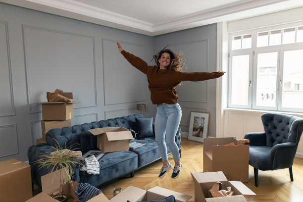 无忧无虑的年轻女子在她的新公寓里高兴地跳着。图片下载