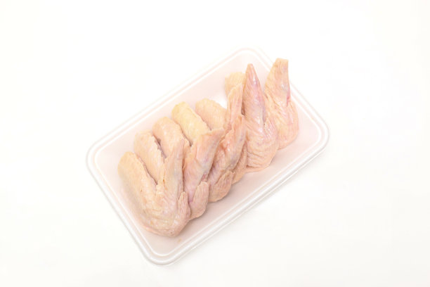 鸡翅肉放在泡沫托盘上，孤立在白色的背景上。图片下载
