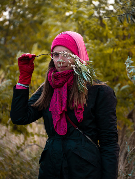 漂亮的微笑快乐的女人在粉红色的帽子野橄榄行走在秋天的森林自然的背景。现实生活的生活方式图片下载