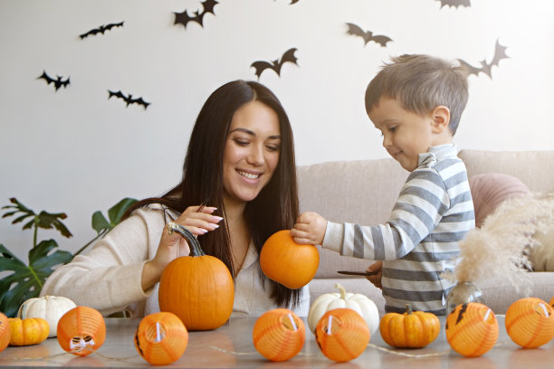 妈妈和儿子在雕刻南瓜。图片下载