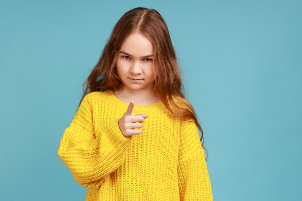 小女孩的肖像站在警告的手势，警告，严厉的表情。图片下载