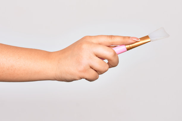 白种人年轻女子手中拿着眼睛刷在孤立的白色背景上图片下载