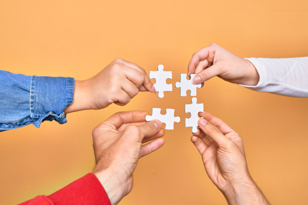 白种人年轻人的手在孤立的黄色背景上连接拼图图片下载