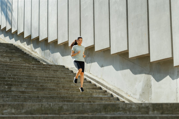 一名身穿运动服的亚洲女子跑下巨大的石阶图片下载