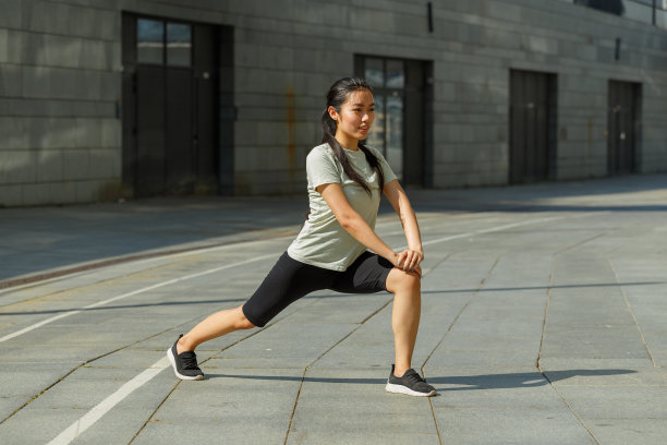 积极的亚洲女人做向前的动态弓步在城市图片下载