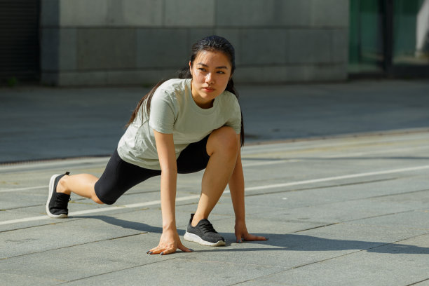 亚洲女子做向前有力的弓步在阳光城市图片下载
