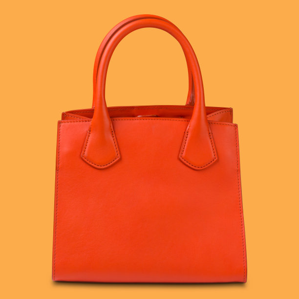 丰富的橙色妇女袋与处理，在黄色背景图片下载