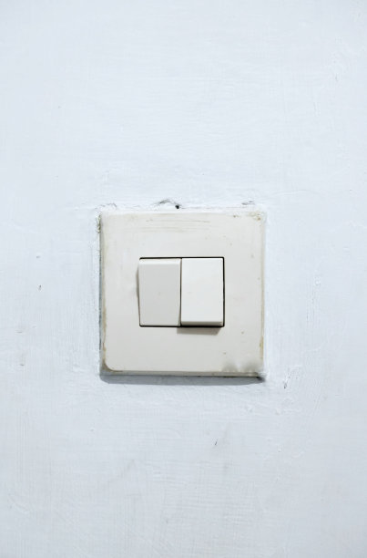 白色墙壁上的白色电灯开关图片下载