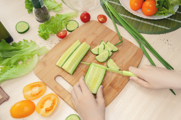 一个孩子的手正在切菜板上的意大利沙拉。俯视图和侧视图。健康的饮食和生活方式。素食主义图片下载
